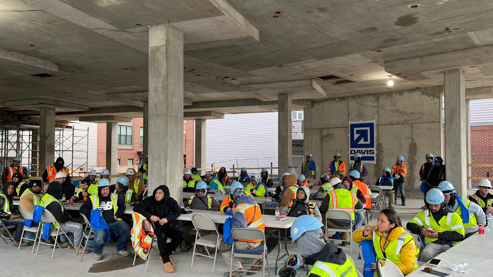 A large group of construction workers gather together to share a meal and celebrate topping out.