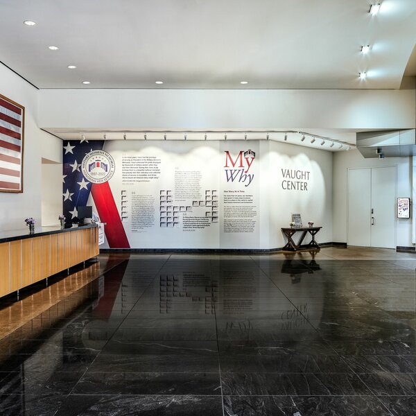 The front desk area at the Military Women's Memorial includes a wall of stories from real servicewomen, and an American flag on display.