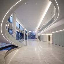 A lobby with marble floors and a helical stair.