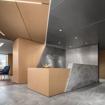 Reception area with a desk as well as wooden and metal accents.