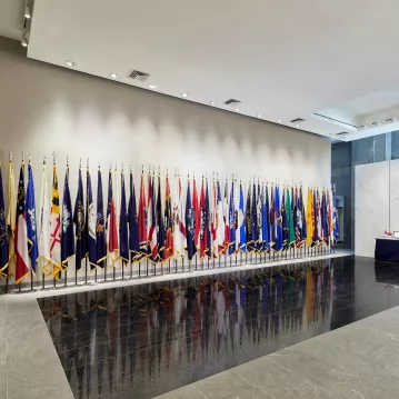 The front desk at the Military Women's Memorial has many flags flags on display, from the American flag to individual states.