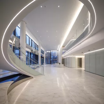 A lobby with marble floors and a helical stair.