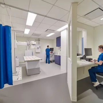 Nurse sitting at computer in a clinical facility room