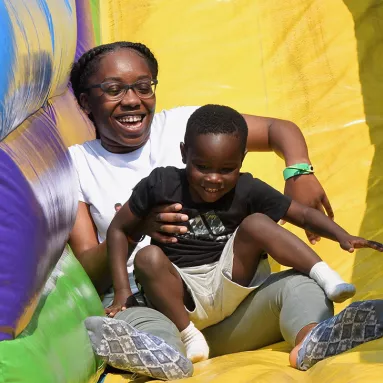 Children on bounce house slide at DAVIS Picnic