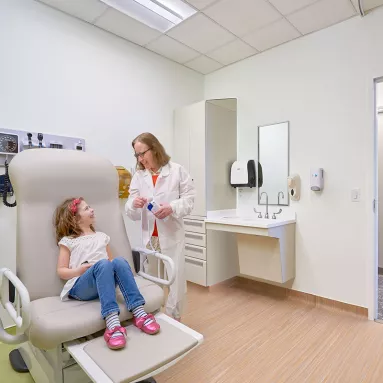 healthcare worker and child patient in medical room  