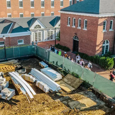 aerial view of school children walking beside in progress construction 