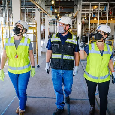 three construction workers walking a project site 