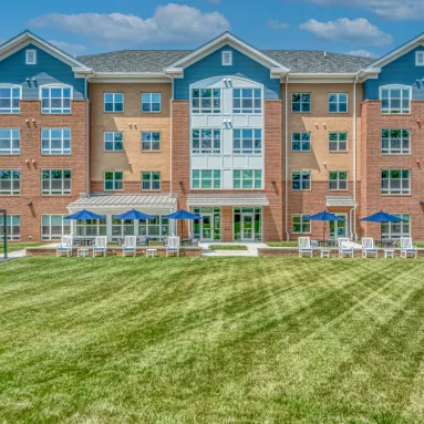 Brick housing development behind a large green patch of grass