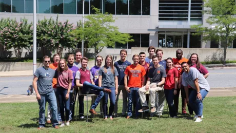 Group of young adults posing in a group in front of a building