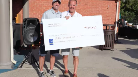 two men holding oversized $50,000 check 