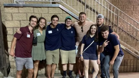 group of young adult interns gathered at bottom of stairs