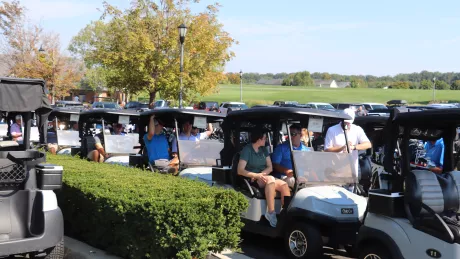 Groups of people sitting in golf carts