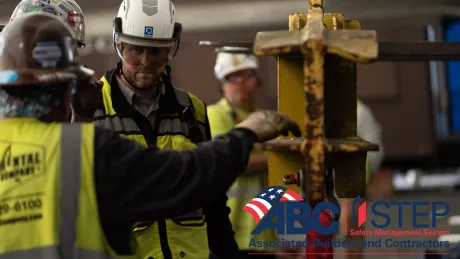 Two men in construction gear look at each other. The logo for ABC's STEP Safety program, which acknowledges DAVIS has reached platinum level, is in the corner.