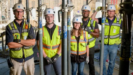 Five people in construction gear pose for a photo.