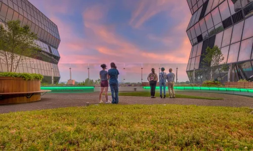 People in green space between two buildings