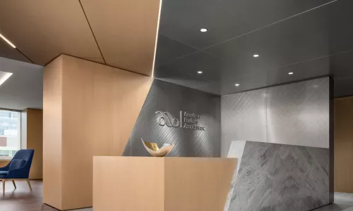 Reception area with a desk as well as wooden and metal accents.