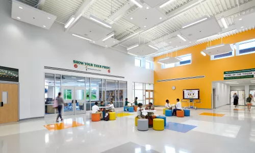 A school's hallway with different children sitting at small tables