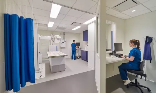 Nurse sitting at computer in a clinical facility room