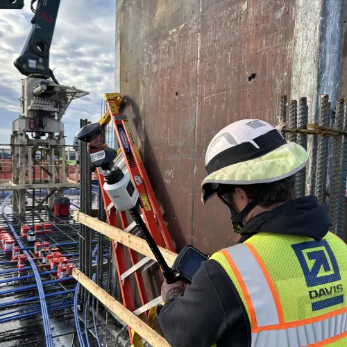 A man in construction gear uses a ground penetrating radar tool.