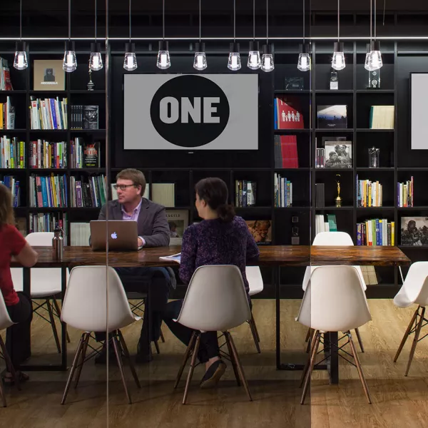 conference room with book cases in the background and people sitting around a table