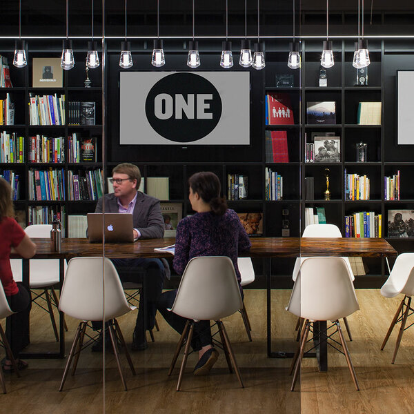 conference room with book cases in the background and people sitting around a table