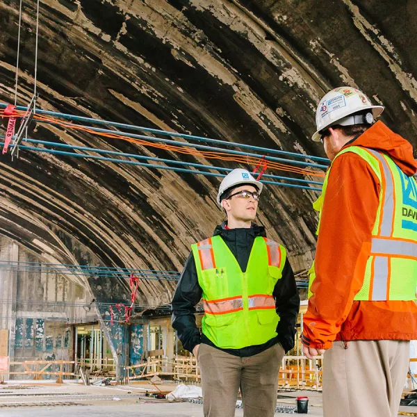 workers in construction safety garb talking in the arena