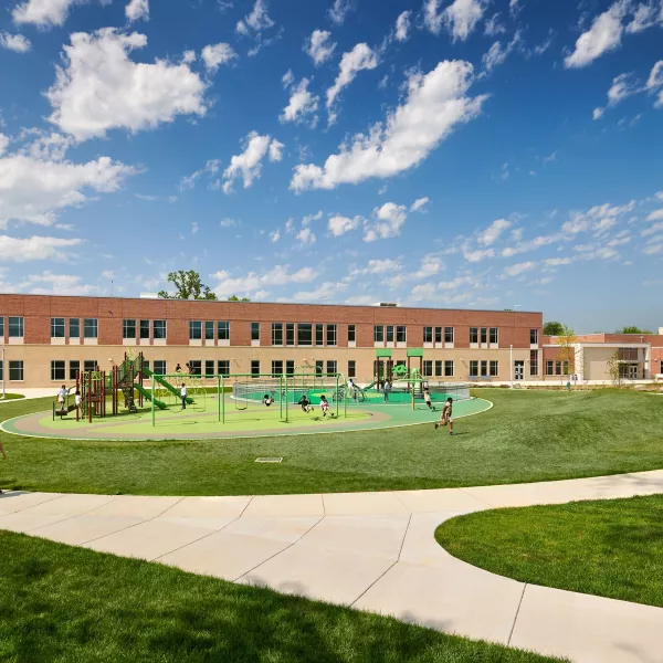 School campus with sidewalks, grass, and the building in the background