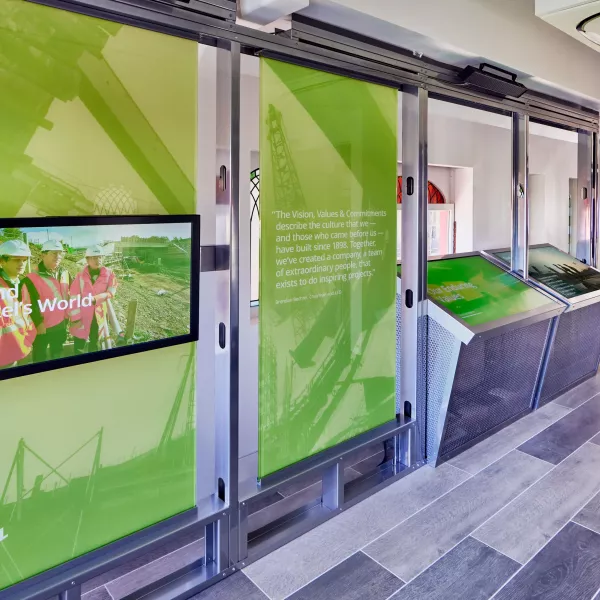 The inside of Bechtel's railcar museum, with tv screens and text depicting the company history