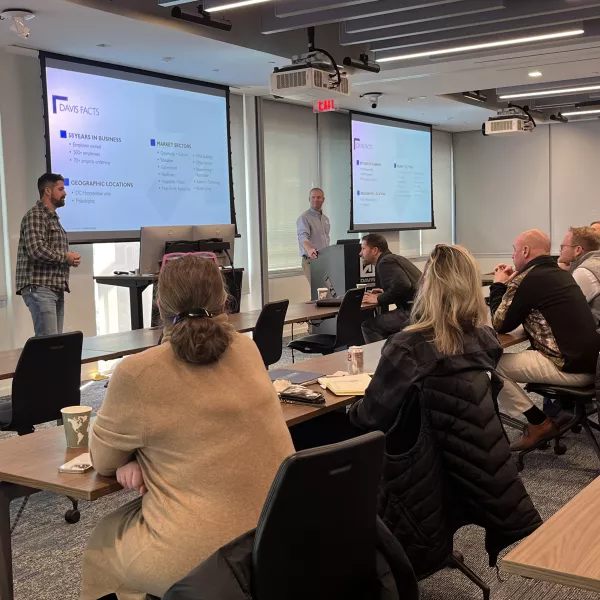 Two presenters and audience in conference room