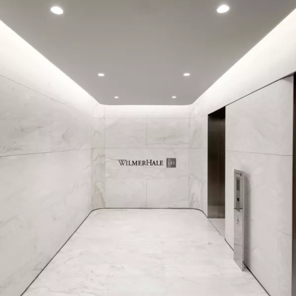 An elevator bay with marble floors.