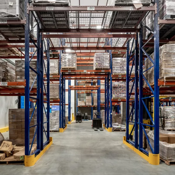 The inside of a storage facility, with shelves and pallets