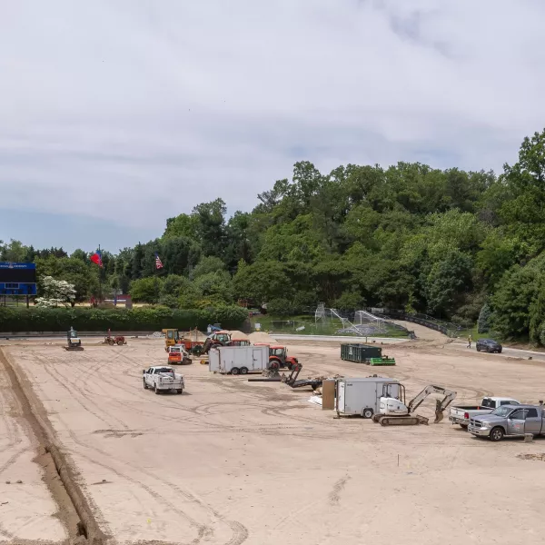Ongong construction site featuring multiple cars and dirt piles.
